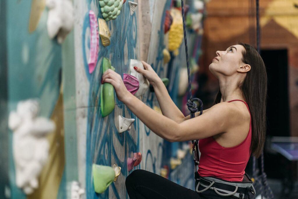 woman wearing a tank top holding the grips of the wall